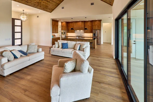Open living room with cathedral pine ceiling, sputnik chandelier, and full-height oak kitchen cabinetry