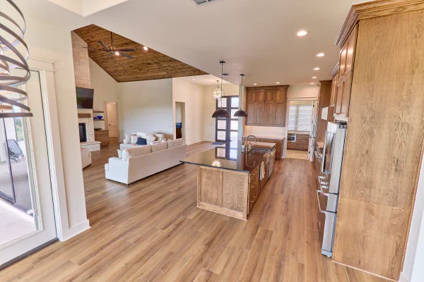 Oak galley kitchen with brass pulls, gas cooktop, black granite island and oversized bronze dome pendant lights