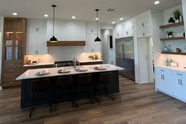 Black island with leather barstools and twin pendants, stained wood hutch cabinet and white perimeter cabinetry